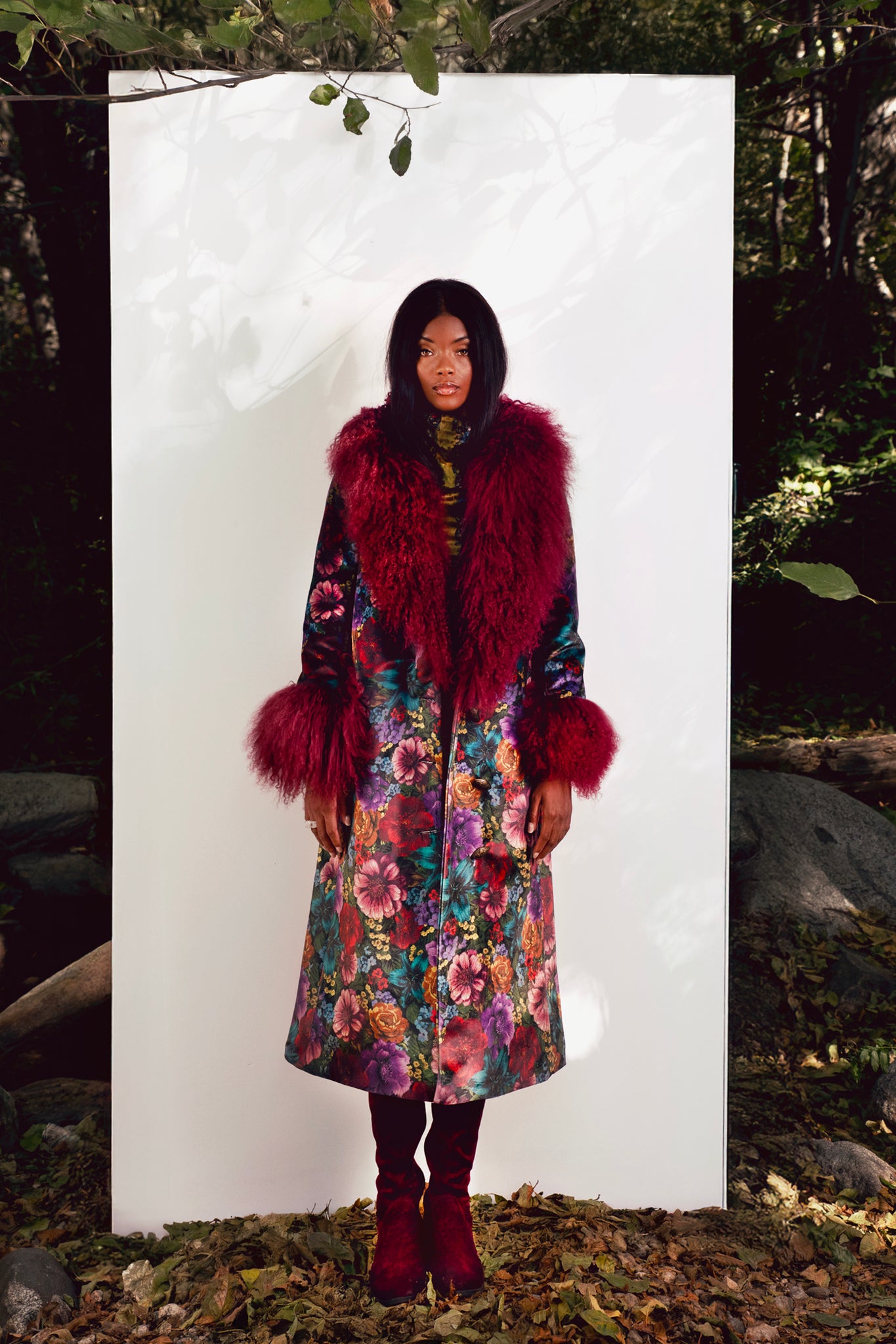 Person wearing a floral coat with red fur against a white background