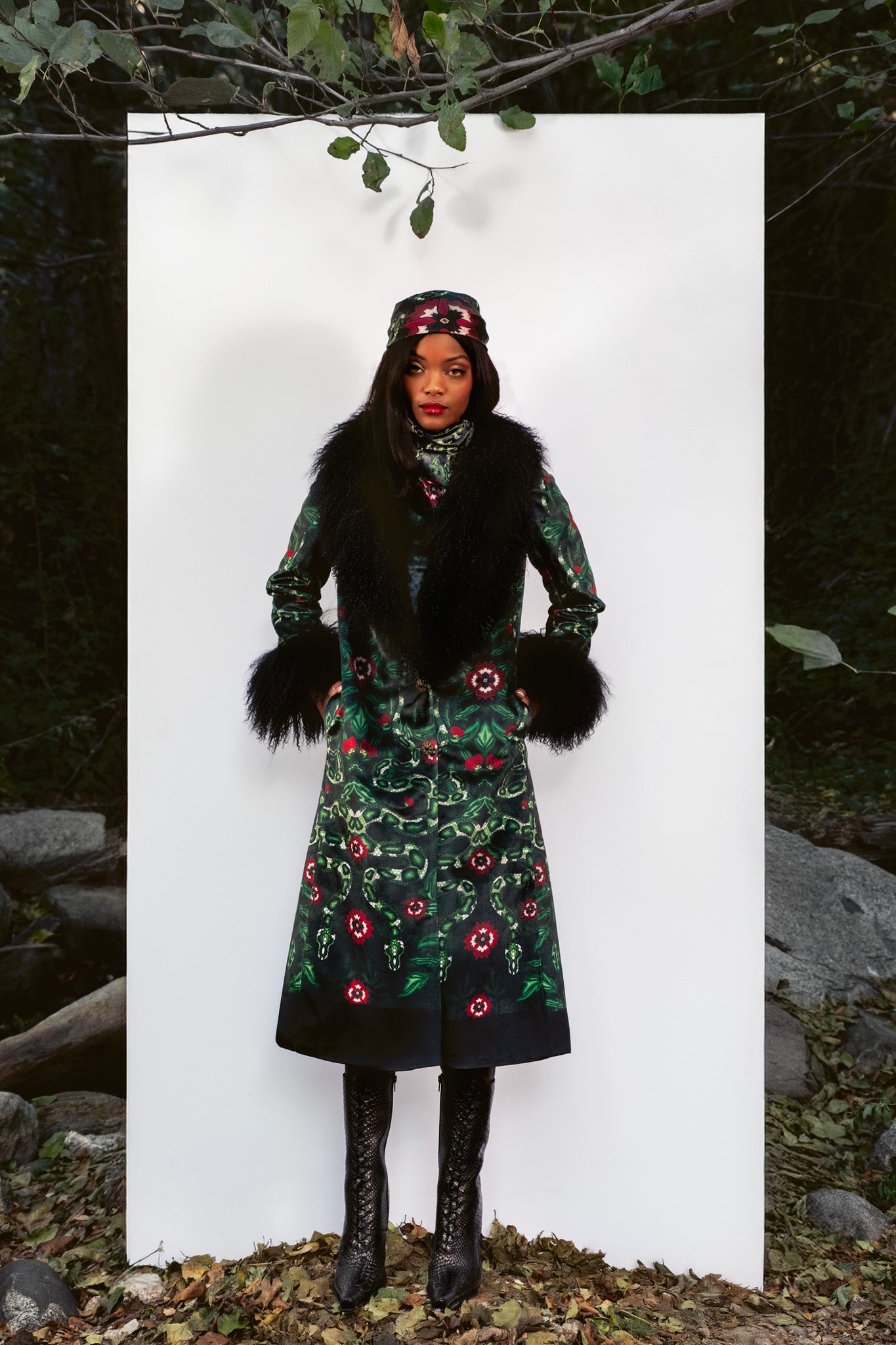 Person wearing a long fur coat against a white background